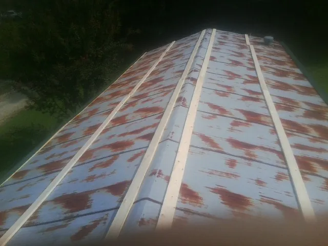 Rusted metal roof panels with new wood purlins before replacement — Storm Damage Roof Repair in Garrett by Roofing Brothers